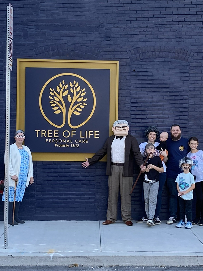 a group standing in front of the tree of life logo